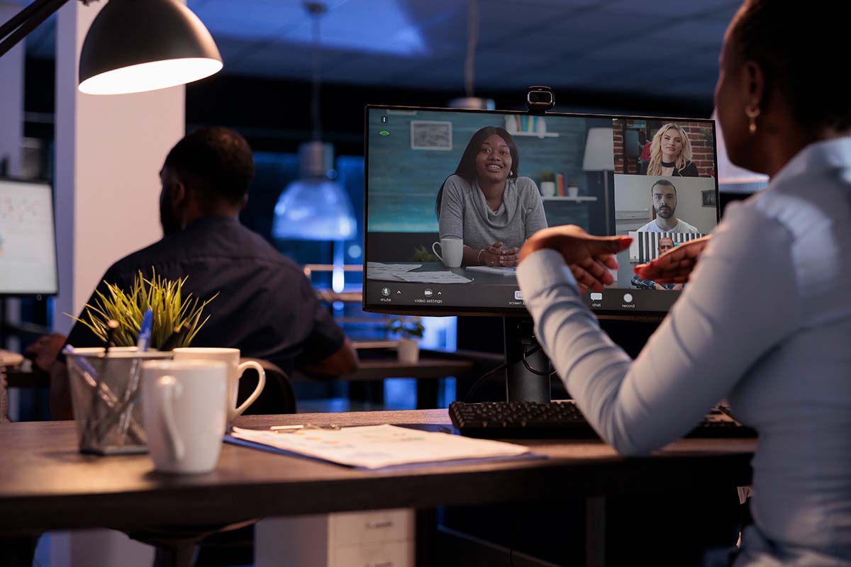 Woman talks to her team over a video conferencing app on her computer.